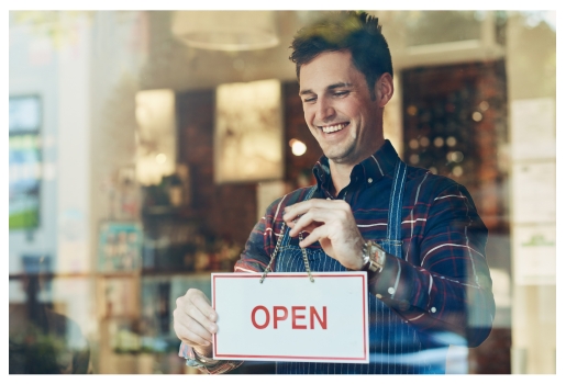 Man Turning an Open Sign for a Business