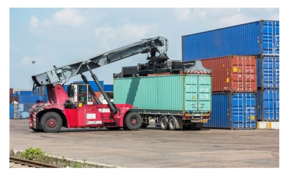 Crane moving cargo container onto a truck